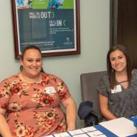 women pose at the front desk